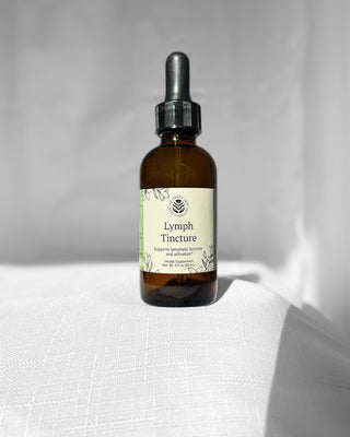 lymph herbal tincture by the fertile glow in a 2 ounce dropper bottle with a white background. Label says lymph tincture herbal supplement supports lymphatic function and activation. tan and green label with black flowers.