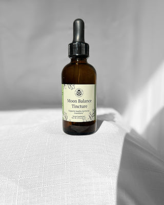 moon balance herbal tincture by the fertile glow in a 2 ounce amber dropper bottle. Label says moon balance herbal supplement support healthy hormonal transitions. tan and green label with black flowers.