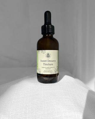 sweet dreams herbal tincture in a 2 ounce dropper bottle by the fertile glow. label says sweet dreams herbal supplement supports restful sleep and relaxation. tan and green label with black flowers.